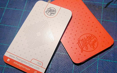 Яркие пластиковые визитки в оранжево-белом оформлении с глянцем